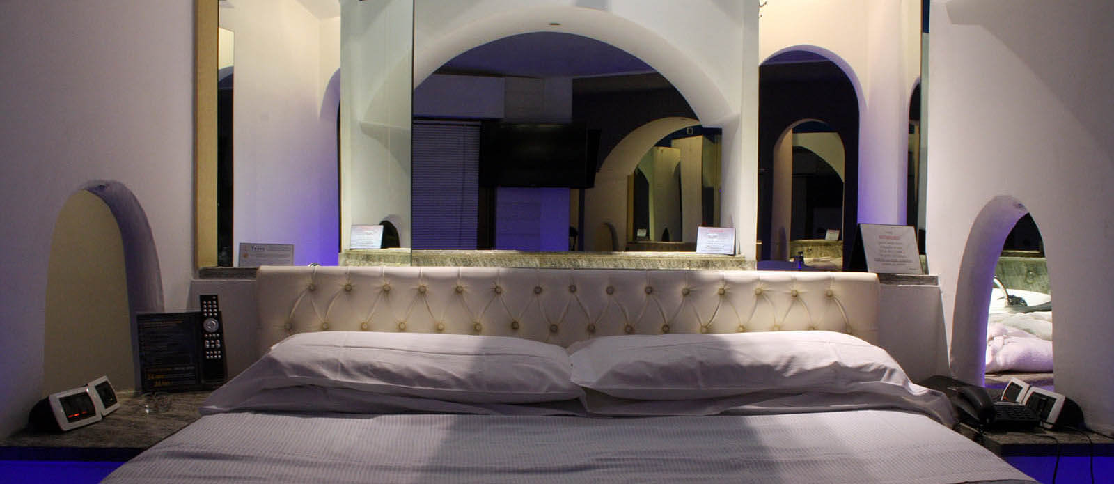 Motel K Junior Suite Santorini vista su letto matrimoniale con vasca idromassaggio dietro al letto Motel K Junior Suite Santorini vista su letto matrimoniale con giochi di specchi particolari vasca dietro al letto camera a tema isole greche