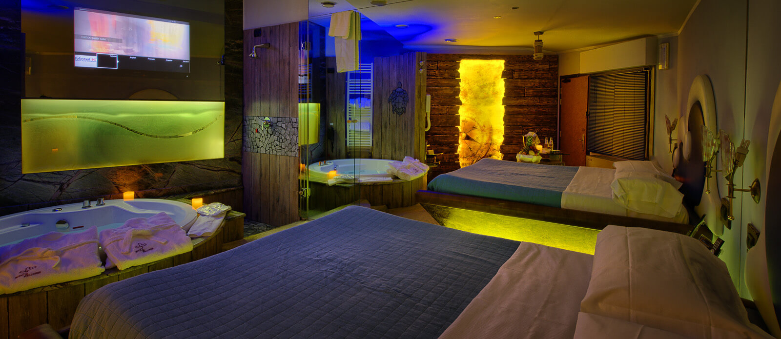 Motel K Junior Suite Tortuga Bay Motel K Junior Suite Tortuga Bay vista su letto matrimoniale con vasca idromassaggio davanti al letto, servizio candele in suite, TV davanti al letto, specchio di fianco al letto, doccia a vista camera a tema pirati dei caraibi